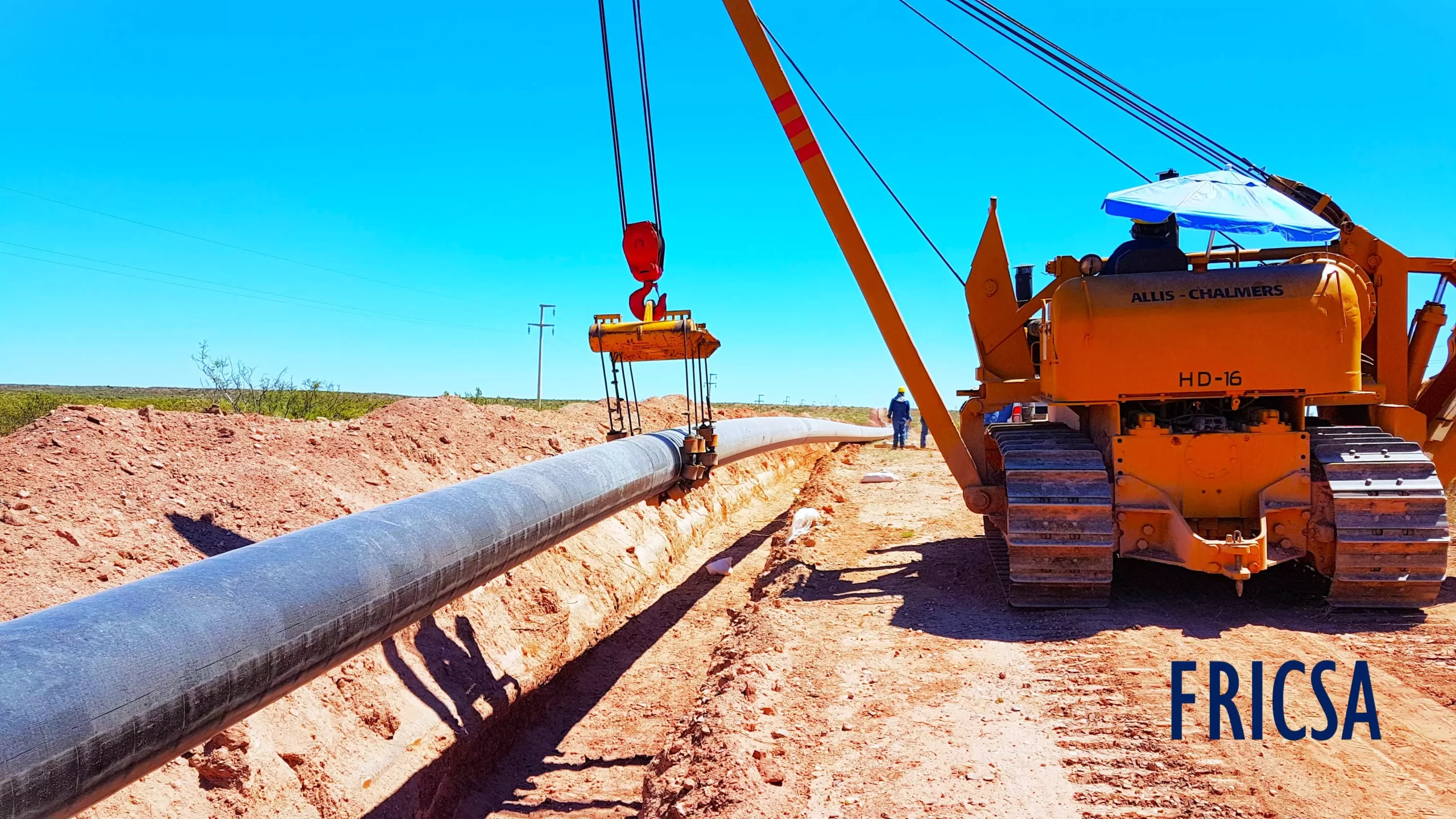 Equipo pesado realizando maniobras de bajada de la cañería